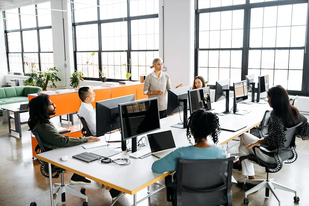 Team members discussing business needs at desks